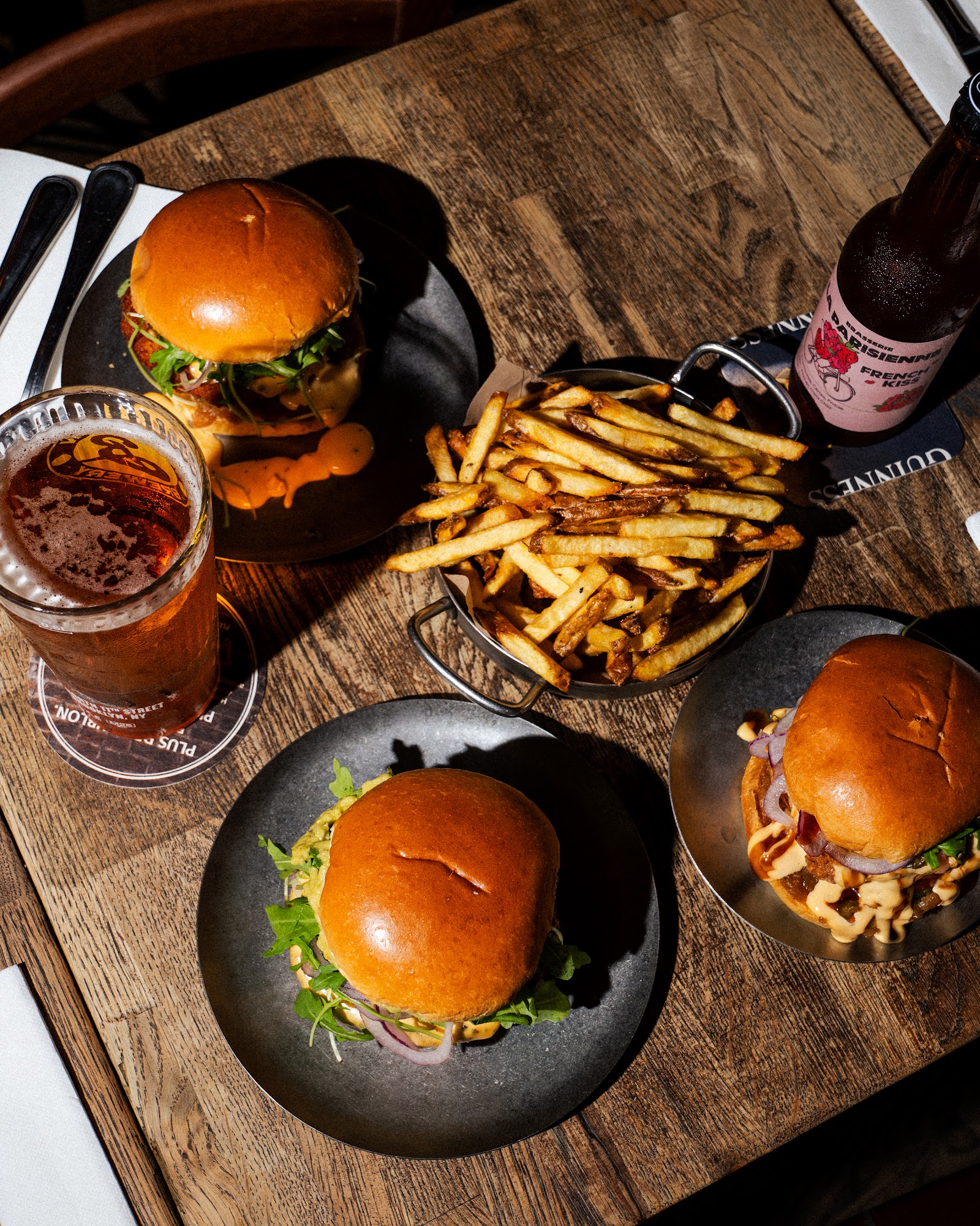 Burgers, frites et bières sur une table du Bowler