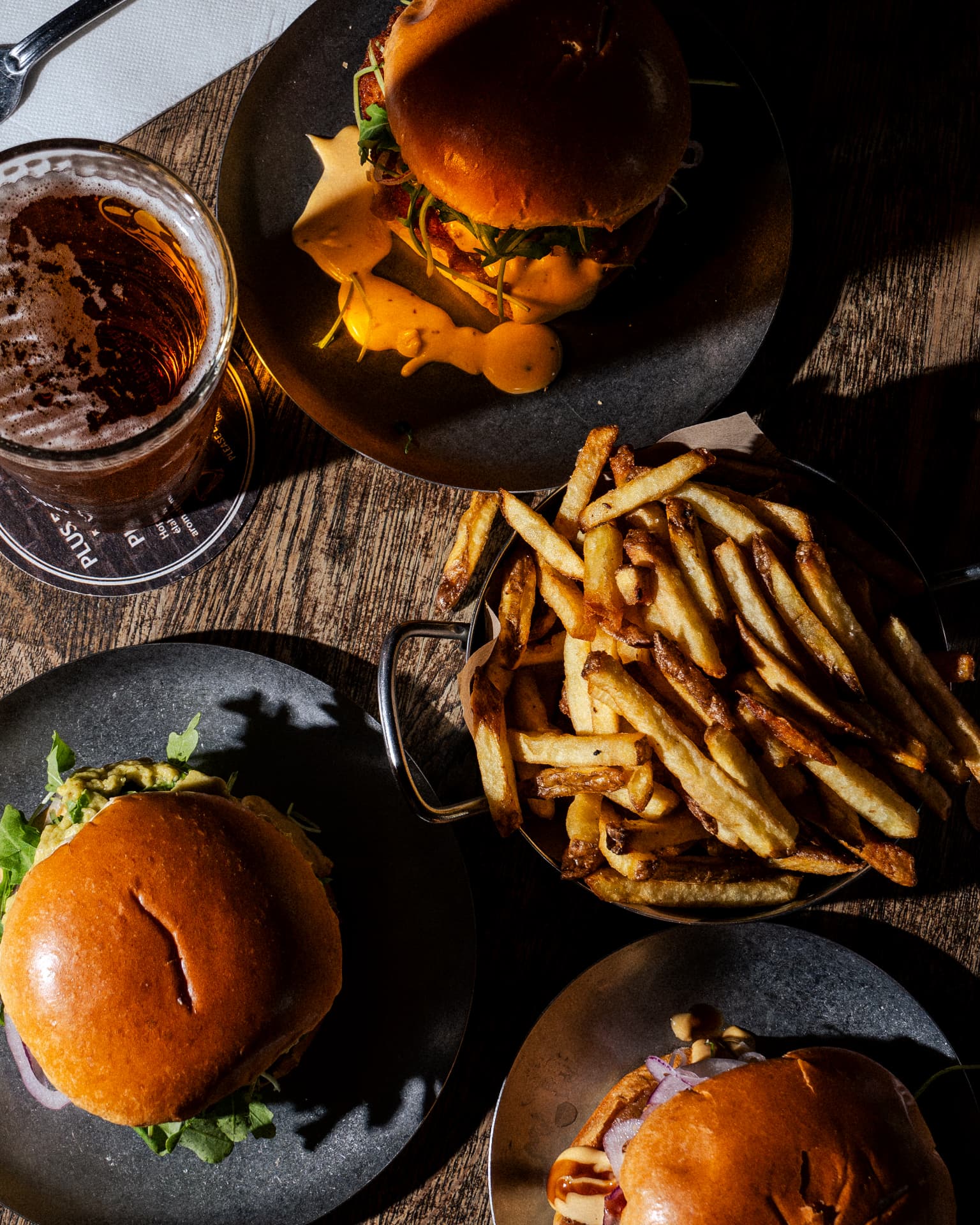 Burgers, frites maison et bière sur une table du Bowler
