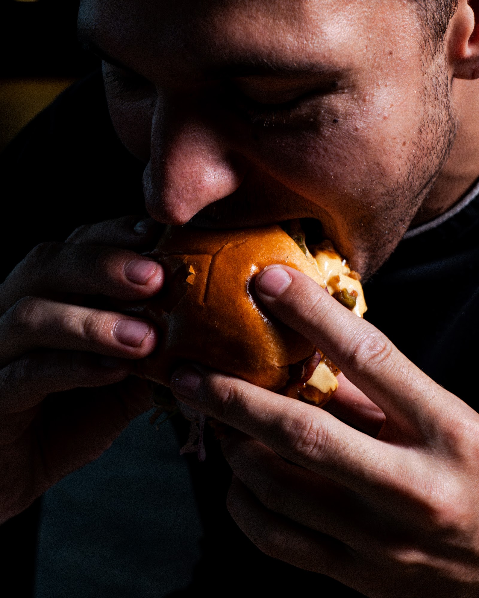 Un client croque dans un burger Bowler & Fries